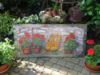 schilderij rode geraniums en gele klompen